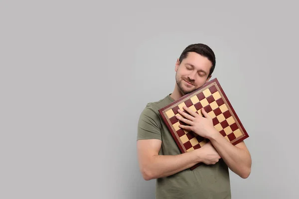 Όμορφος Άντρας Κρατάει Την Σκακιέρα Ανοιχτό Γκρι Φόντο Χώρος Για — Φωτογραφία Αρχείου