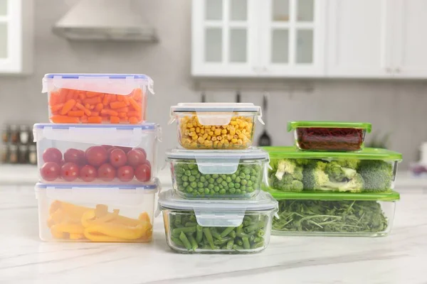 stock image Glass and plastic containers with different fresh products on white marble table in kitchen. Food storage