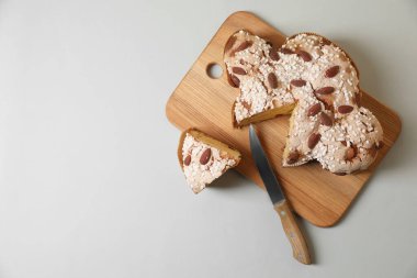 Açık gri masa üzerinde leziz İtalyan Paskalya güvercini pastası (geleneksel Colomba di Pasqua) bulunan bir pano. Metin için boşluk