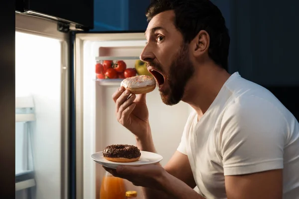 晚上在厨房冰箱边吃甜甜圈的人 坏习惯 — 图库照片