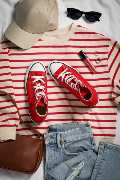 Ζεύγος Από Stylish Κόκκινα Sneakers Ρούχα Και Αξεσουάρ Λευκό Ύφασμα — Φωτογραφία Αρχείου