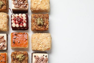 Farklı lezzetli pastaların parçaları beyaz masada, düz yerde. Metin için boşluk