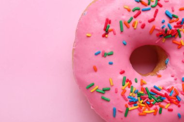 Pembe arka planda serpiştirilmiş lezzetli jöleli donut, yakın plan. Metin için boşluk