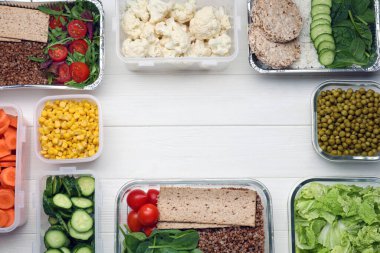 Beyaz ahşap masa üzerinde taze ürünleri olan farklı konteynırlar. Metin için boşluk