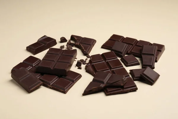 Trozos Deliciosas Barras Chocolate Sobre Fondo Beige —  Fotos de Stock