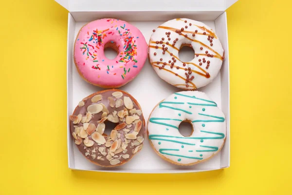 Sarı arka planda lezzetli jöleli çöreklerle dolu bir kutu.