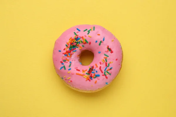 Вкусный Пончик Глазурью Украшенный Брызгами Желтом Фоне Вид Сверху — стоковое фото