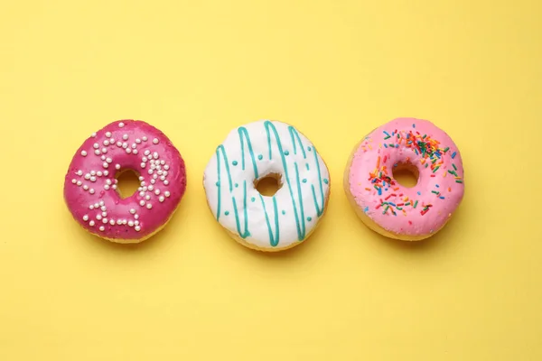 Вкусные Глазированные Пончики Желтом Фоне Плоская Укладка — стоковое фото