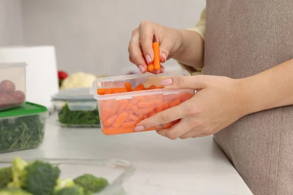 Woman Putting Carrots Container Fresh Vegetables White Marble Table Kitchen — Stock Photo, Image
