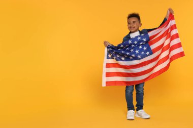 4 Temmuz - ABD 'nin Bağımsızlık Günü. Sarı arka planda Amerikan bayrağı olan mutlu çocuk, mesaj için boşluk