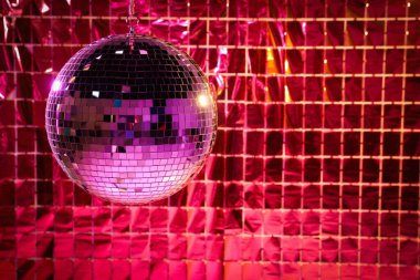 Pembe ışık altında folyo parti perdesine karşı parlak disko topu, metin için yer