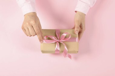 Pembe arka planda hediye kutusu olan kadın, üst manzara.