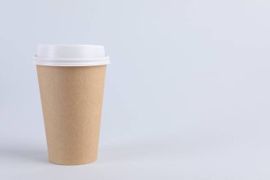 Arka planda plastik kapaklı kağıt bardak, metin için boşluk. Kahve hazır.