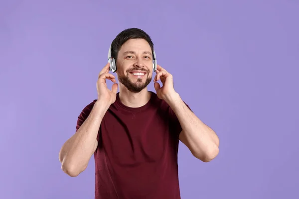Hombre Feliz Auriculares Disfrutando Música Sobre Fondo Púrpura — Foto de Stock