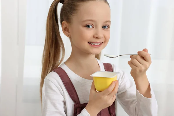 可爱的小女孩 在屋里带着美味的酸奶 — 图库照片