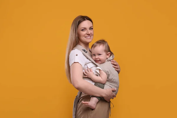 Moeder Houdt Haar Kind Draagdoek Babydrager Oranje Achtergrond Ruimte Voor — Stockfoto