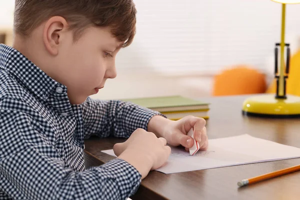 Little Boy Erasing Mistake His Notebook Wooden Desk Indoors — Stock Photo, Image