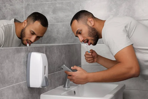 Mladý Muž Používá Smartphone Při Čištění Zubů Koupelně Internetová Závislost — Stock fotografie