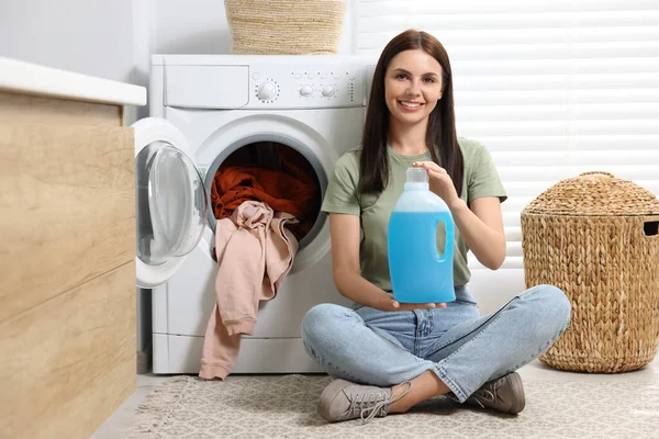 Mulher Sentada Chão Perto Máquina Lavar Roupa Segurando Amaciador Tecido — Fotografia de Stock