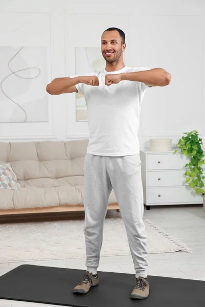 男人在家里的健身垫上做晨练 — 图库照片