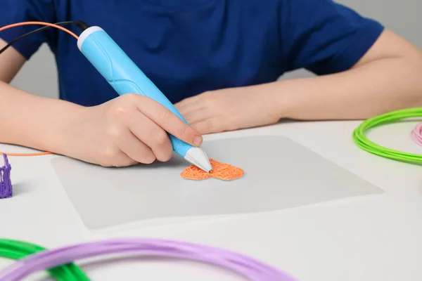 stock image Boy drawing with stylish 3D pen at white table, closeup