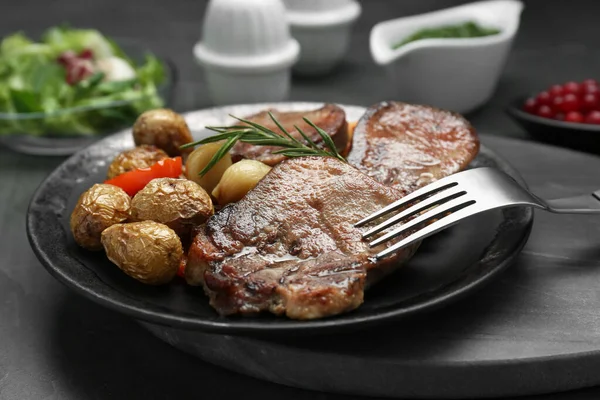 味道鲜美的牛肉片 迷迭香和土豆放在灰色桌子上 特写镜头 — 图库照片