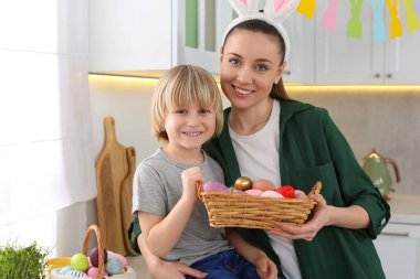 Anne ve oğlu mutfakta paskalya yumurtası yiyorlar.