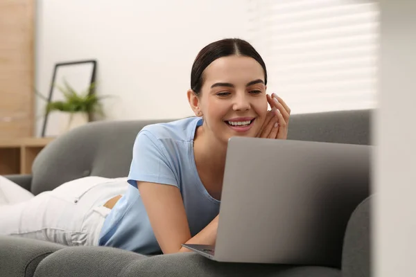 快乐的女人在家沙发上和笔记本电脑一起工作 — 图库照片