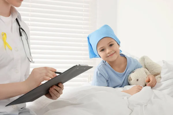 소아암이요 클립보드를 의사와 병원에서 장난감 토끼를 데리고 — 스톡 사진
