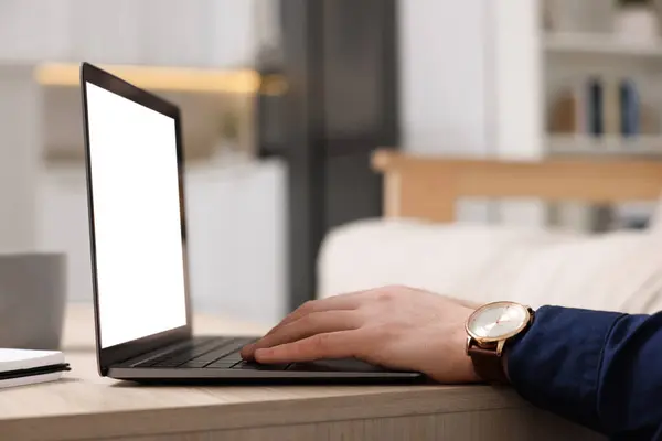 stock image Man working on laptop at wooden desk indoors, closeup