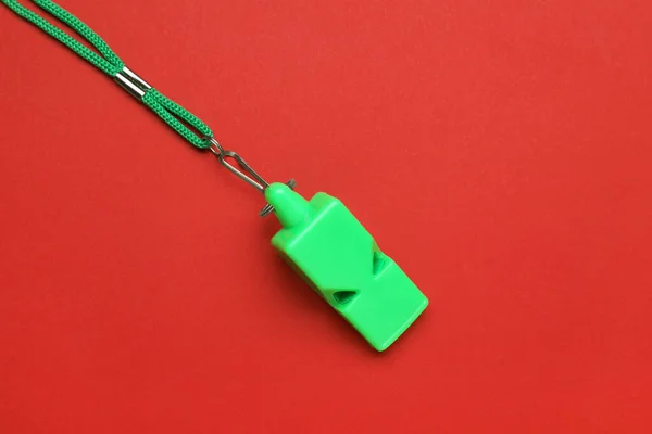 Kırmızı Arka Planda Kablosu Olan Yeşil Bir Islık — Stok fotoğraf