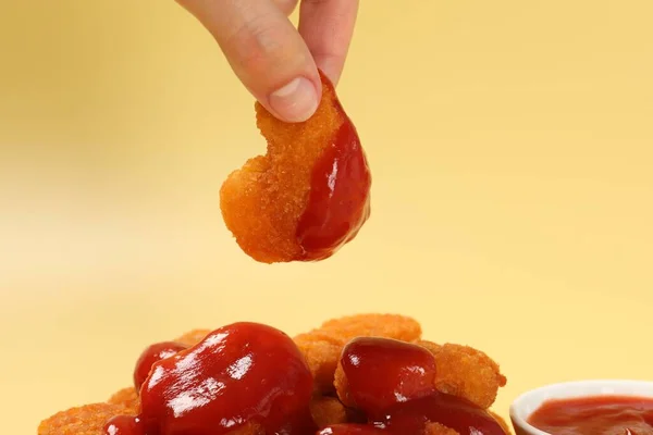 Mulher Segurando Nugget Frango Delicioso Com Ketchup Fundo Amarelo Pálido — Fotografia de Stock