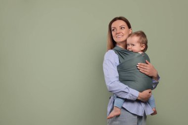 Anne çocuğunu sarıp zeytin arka planında tutuyor. Metin için boşluk