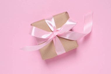 Pembe arka planda fiyonklu güzel hediye kutusu, üst manzara