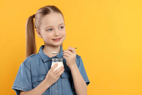 Söt Liten Flicka Med Välsmakande Yoghurt Orange Bakgrund Utrymme För — Stockfoto