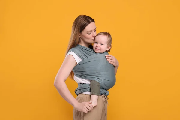 Madre Sosteniendo Hijo Una Envoltura Bebé Sobre Fondo Naranja —  Fotos de Stock