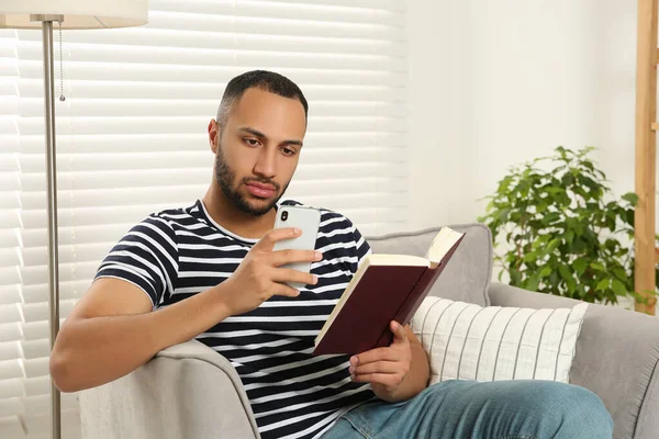 Junger Mann Mit Smartphone Beim Lesen Von Büchern Hause Internetsucht — Stockfoto