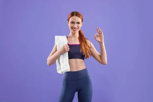 Frau Trägt Sportbekleidung Mit Handtuch Auf Violettem Hintergrund — Stockfoto