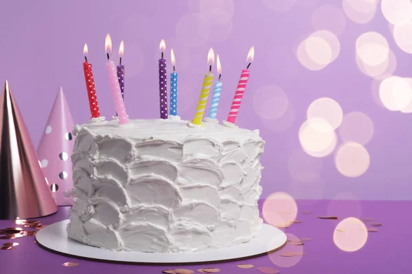 美味的蛋糕 有燃烧的蜡烛和紫色背景的节日装饰 案文的篇幅 — 图库照片