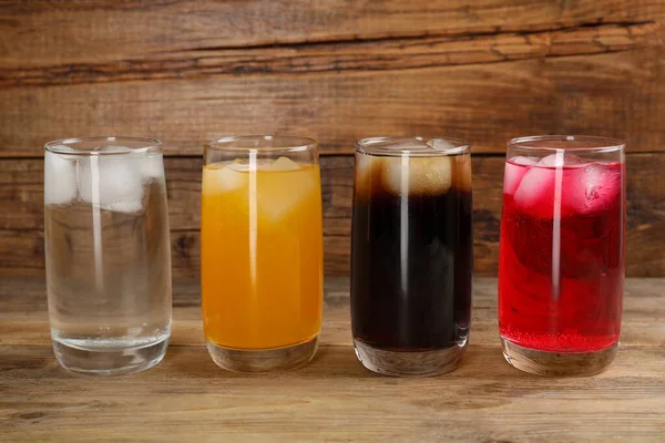Farklı Tazeleyici Soda Bardakları Ahşap Masada Buz Küpleri — Stok fotoğraf