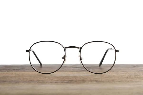 Óculos Elegantes Com Moldura Metal Mesa Madeira Contra Fundo Branco — Fotografia de Stock