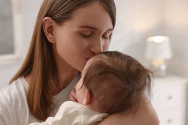 Mutlu anne küçük bebeğini öpüyor, yakından.