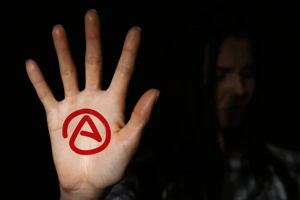 Young woman showing palm with atheism sign in darkness, focus on hand