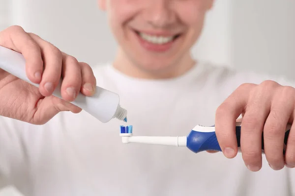 Άνθρωπος Πιέζει Οδοντόκρεμα Από Σωλήνα Ηλεκτρική Οδοντόβουρτσα Θολή Φόντο Closeup — Φωτογραφία Αρχείου