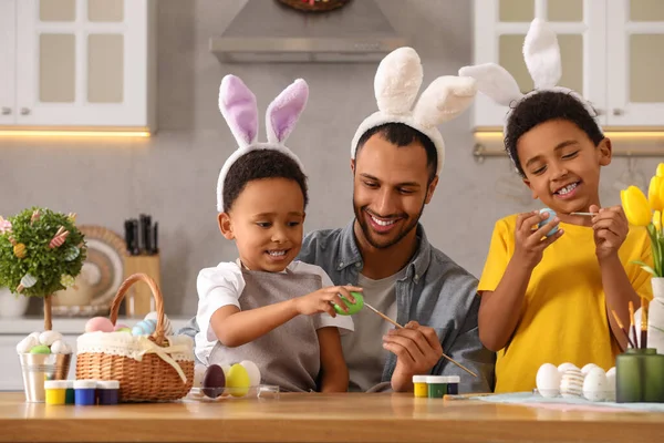 Mutlu Afrikalı Amerikalı Baba Tatlı Çocukları Mutfaktaki Masada Paskalya Yumurtası — Stok fotoğraf