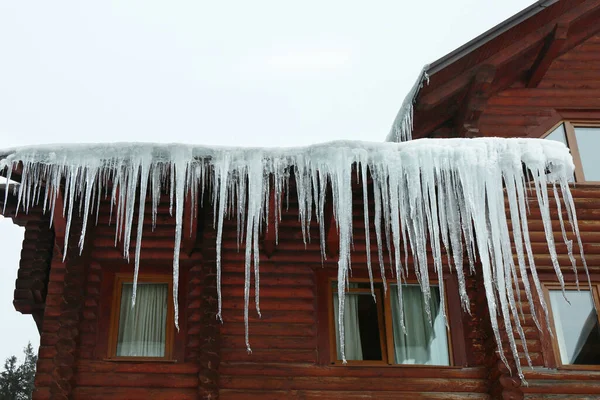 屋根の上につららと家 低角度のビュー 冬の季節 — ストック写真