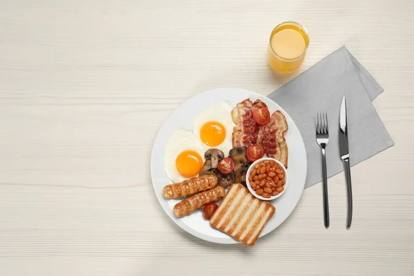 白い木製のテーブルの上に揚げ卵 ソーセージ キノコ ベーコンとトーストのプレートは テキストのためのスペースとフラットレイアウト 伝統的な英語の朝食 — ストック写真