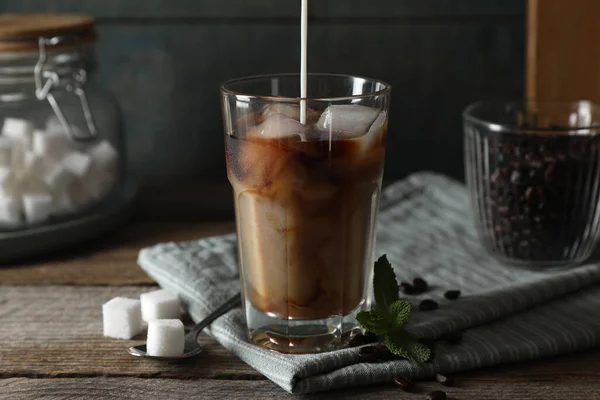 Tej Öntése Egy Pohár Finom Jeges Kávéba Menta Cukorkocka Asztalra — Stock Fotó