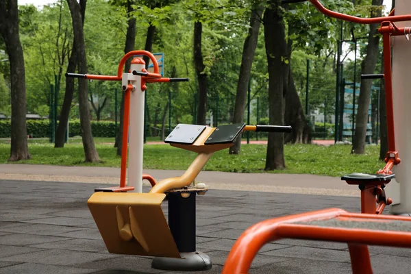 Stock image Empty outdoor gym with back extensioner, twister and surfer