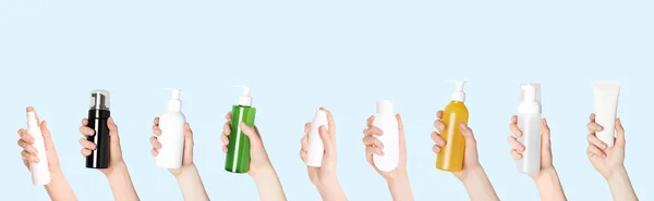 Donne Che Tengono Bottiglie Tubi Diversi Prodotti Cosmetici Sfondo Azzurro — Foto Stock